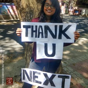Girl holding a placard that says 'thank you next'